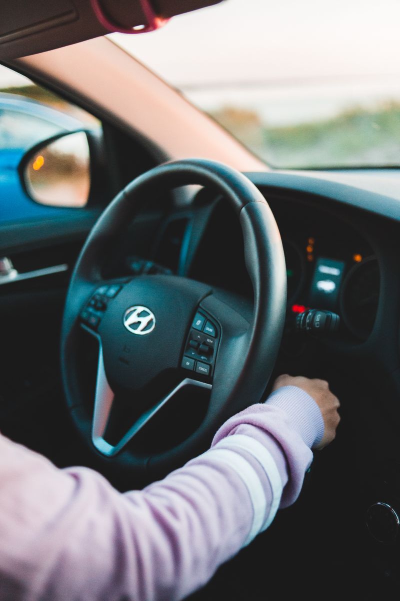 Person driving car with hands on steering wheel representing permissive use