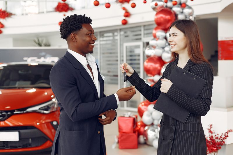 Man standing next to car representing insurance documentation