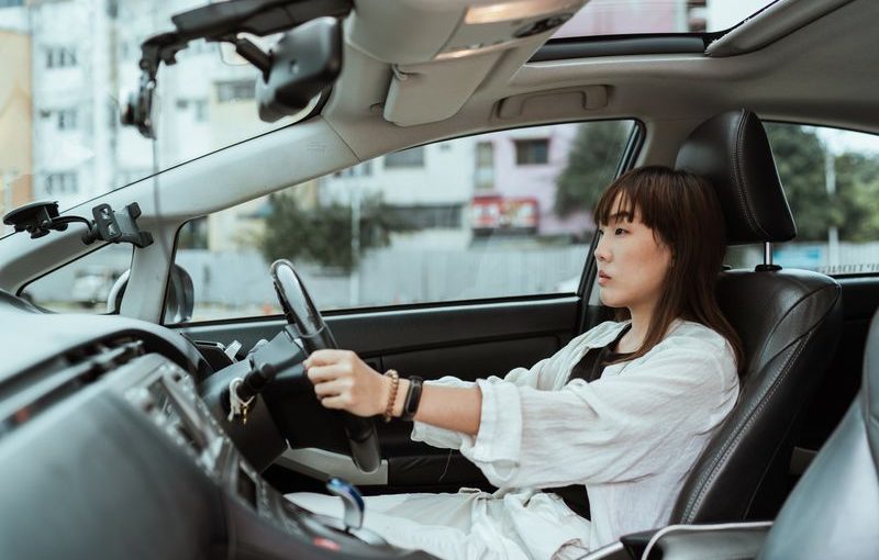 Young student driver sitting in car