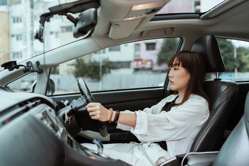 Young student driver sitting in car