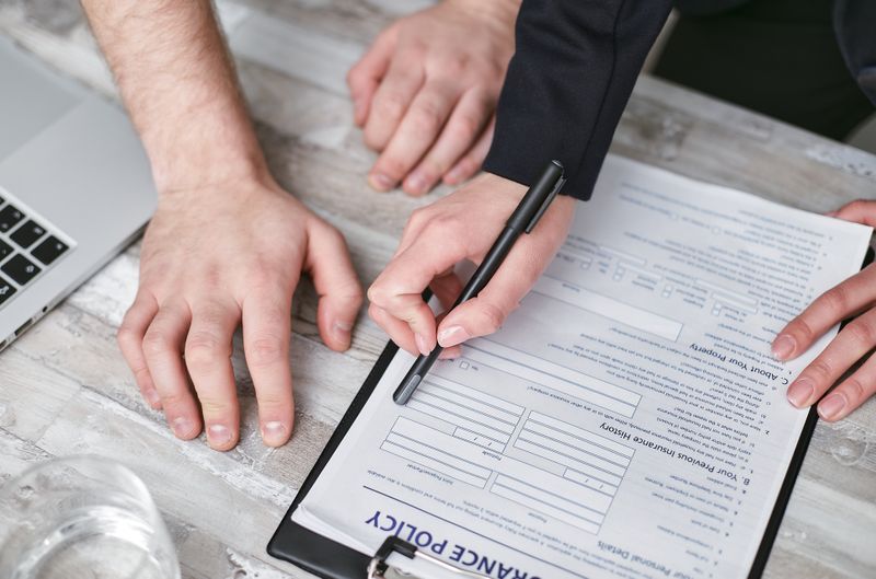 Person comparing car insurance policies and documents