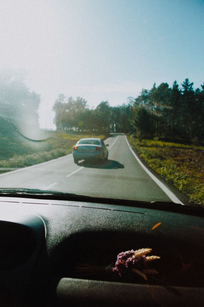 young person driving car on road