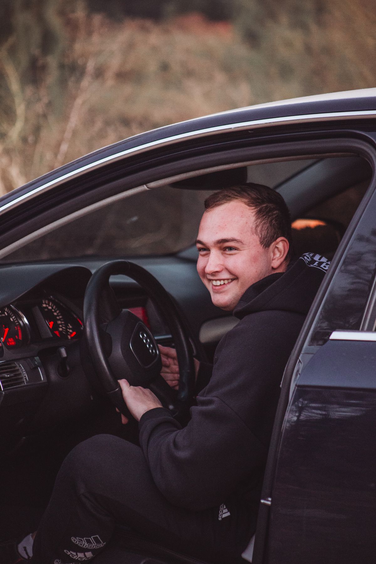 Young man leaning on a car
